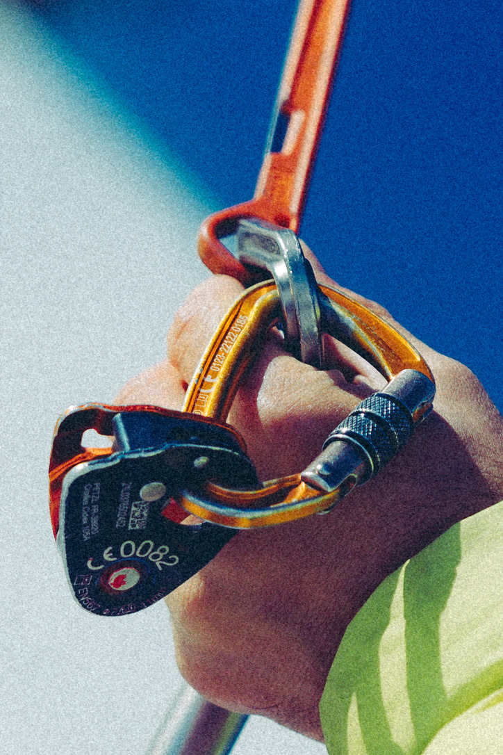 Close view of a climber holding orange carabiners during the Arc’teryx ABA Hero campaign